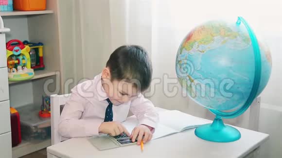 一个小孩用计算器重新计算他的存款视频的预览图
