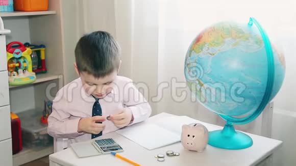 小男孩把他的积蓄记在计算器上视频的预览图