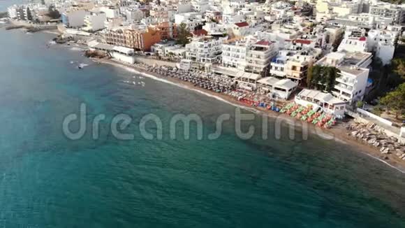 希腊克里特岛阳光明媚的早晨沿着城市海滩大海和酒店进行空中飞行视频的预览图