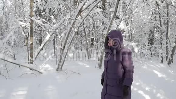 在冬天的森林里一位年长的女士走过镜头视频的预览图