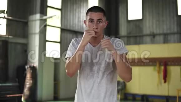 强壮的活跃男子在拳击和拳击无形对手的肖像在健身房训练慢动作关门视频的预览图