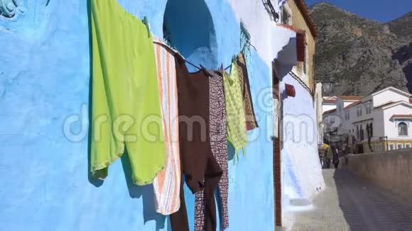 干燥的衣服挂在摩洛哥的蓝墙城市厨师沙文里视频的预览图