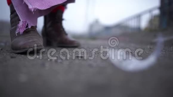 在一个无家可归的人肮脏的靴子旁边一个玻璃砸在沥青上玻璃碎片飞散开来视频的预览图