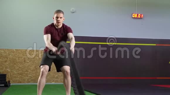 男子在健身房进行交叉健身训练时用绳子做运动视频的预览图
