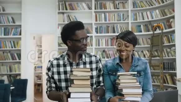 非洲男女学生手里拿着一堆书视频的预览图