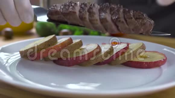 厨师把肉片和炒菜放在盘子里食品设计与造型准备好的肉视频的预览图