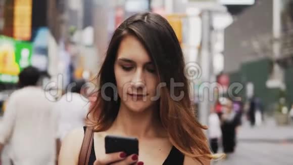美国纽约市中心拥挤的年轻美女使用智能手机的肖像女孩类型的信息视频的预览图
