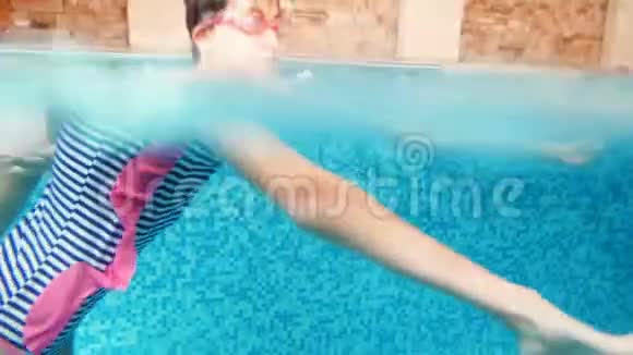 两个十几岁的女孩在室内游泳池水下潜水的4k视频儿童享受水的乐趣视频的预览图