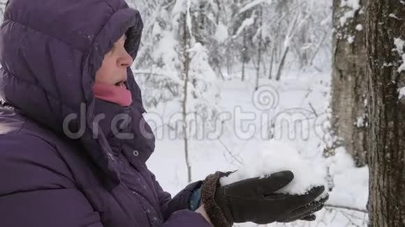 把一把新鲜的蓬松的雪堆放在高级妇女的身边视频的预览图