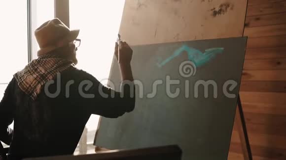艺术大师正在用画笔在他的画上画蓝天视频的预览图