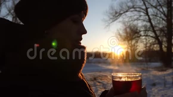 女孩手里拿着杯子手里拿着热茶有蒸汽视频的预览图