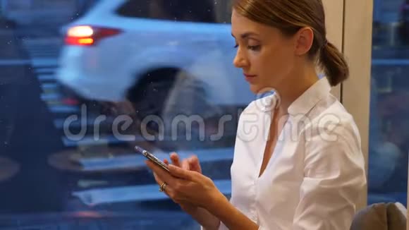有智能手机的女人坐在繁忙的街道和交通上视频的预览图