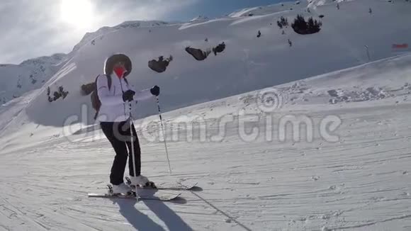 山坡上的滑雪者推着他的棍子往下滑视频的预览图