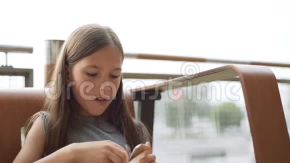 一个小女孩正在夏天的咖啡馆里吃薯条4k视频的预览图