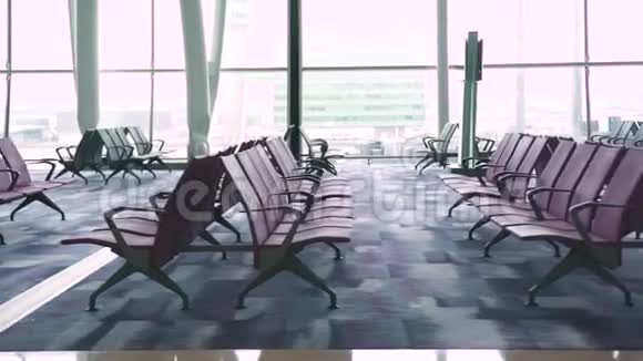 在机场候机室等候飞机的椅子在窗口背景机场等候区及窗口视频的预览图