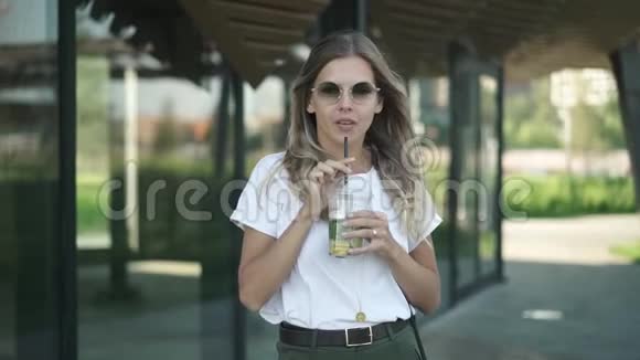 一位戴墨镜的金发美女在夏日喝冷饮视频的预览图