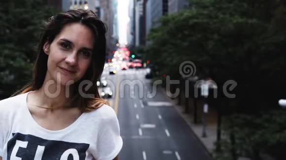 美国纽约市中心的桥上站着一位年轻美丽的女士微笑着看着摄像机的画像视频的预览图