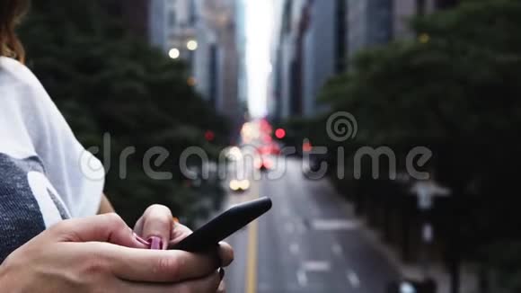 近距离观看女性手握住和使用智能手机站在美国纽约的桥上视频的预览图