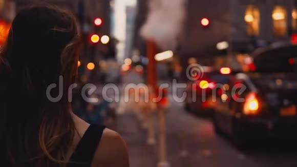 近景的年轻美女站在纽约美国市中心附近的交通道路靠近烟斗视频的预览图