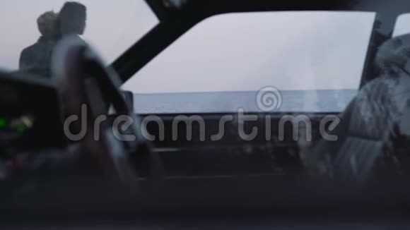 从海边的一对夫妇的老式汽车上看视频的预览图