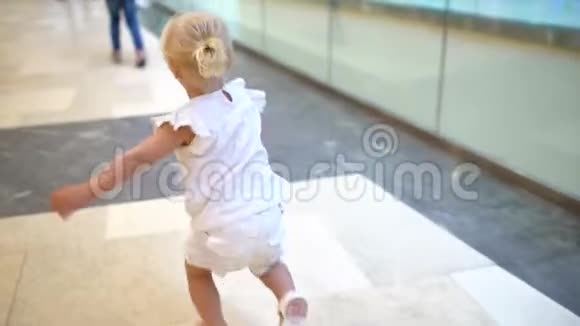 现代家庭的购物日小女孩和家人一起在大购物中心散步孩子在购物中心跑视频的预览图