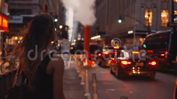 年轻的美女站在美国纽约靠近烟斗的交通道路附近等待出租车视频的预览图