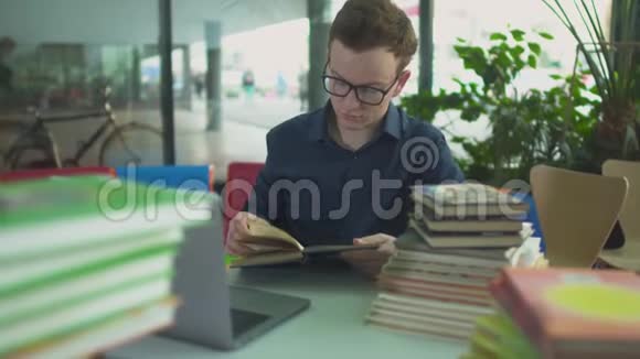 这个学生正在图书馆桌上学习许多书视频的预览图
