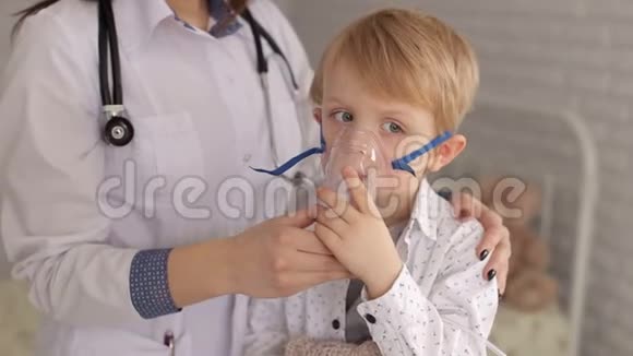 一位女儿科医生给医院里的一个小男孩戴上了吸入器面罩视频的预览图