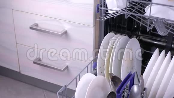 厨房洗碗机篮子里肮脏的白色盘子和餐具视频的预览图