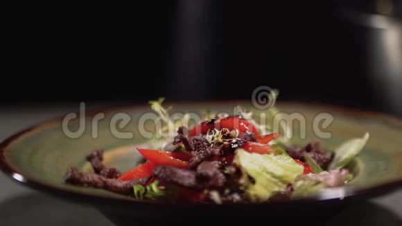 芝麻落在盘子里配上新鲜沙拉的原料快关门视频的预览图