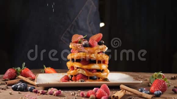 厨师在美味的煎饼上撒糖粉慢动作面粉被筛到煎饼上提供薄煎饼堆视频的预览图