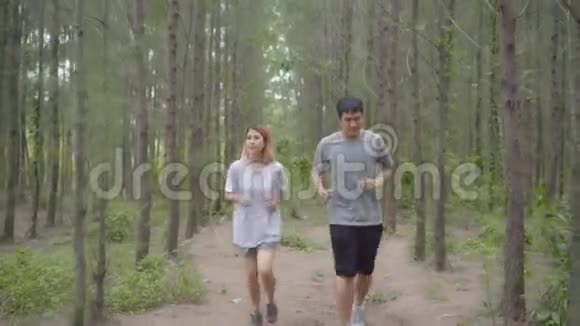 健康的年轻运动运动员亚洲运动员穿着运动服装在森林小径上跑步和慢跑视频的预览图