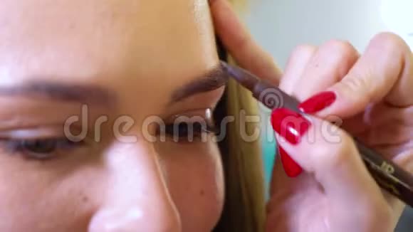 美妆师在美容院为女性模特做眉形矫正视频的预览图