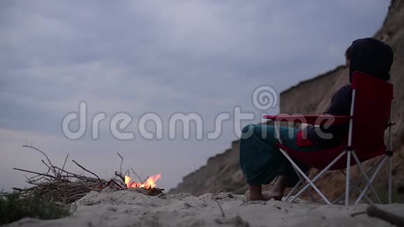 海滩上篝火旁的女孩视频的预览图