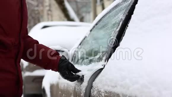 男人在坐在车里之前先把雪从雪腿上抖下来视频的预览图
