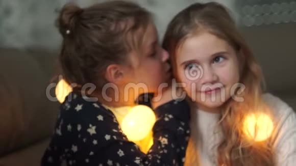 女学生在家里举行睡衣派对分享秘密女孩在姐姐的耳边窃窃私语两人都笑得很开心视频的预览图