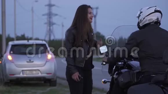 4骑摩托车的人在附近停了下来她的车在路上抛锚了视频的预览图