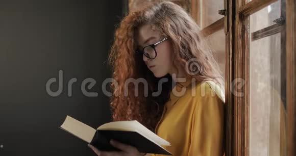 年轻漂亮的女孩思考和阅读这本书视频的预览图