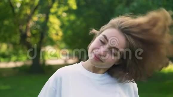 一位留着短发的年轻女子在夏季公园玩视频的预览图