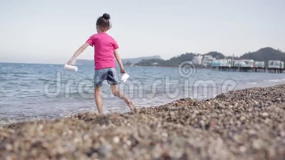 女孩在沙滩上玩石子视频的预览图