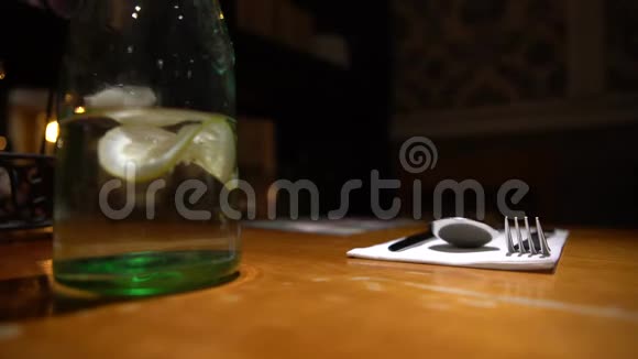 4K服务员在有木桌的餐厅里端着一杯水和柠檬视频的预览图