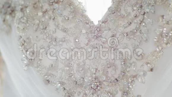 白色婚礼礼服上闪闪发光的莱茵石刺绣的特写视频的预览图