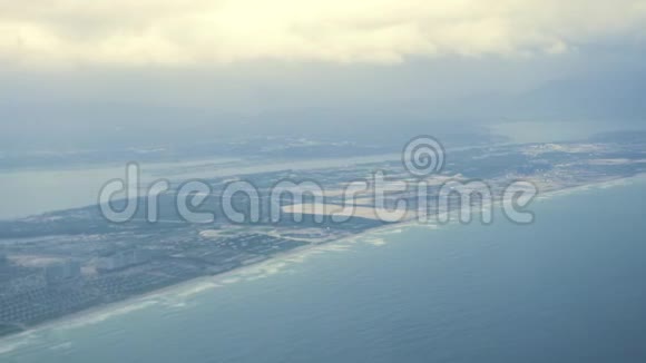 从飞机窗口到城市在海岸边飞行从窗口飞机上俯瞰现代城市视频的预览图