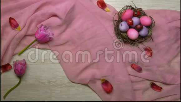 双手放在桌子上放一个托盘上面放着带鸡蛋的复活节巢背景上的茶视频的预览图