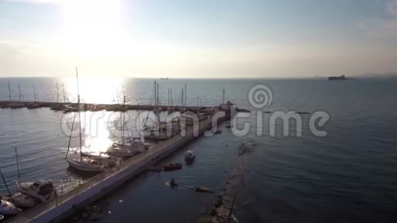 日落时在希腊卡拉马里亚塞萨洛尼基地区的码头游艇的鸟瞰图用无人驾驶飞机前进视频的预览图