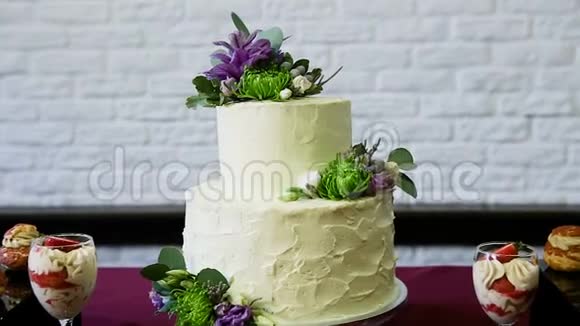 放大两层白色蛋糕上面装饰着鲜花视频的预览图