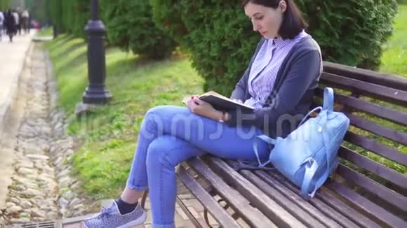 一个跪在长凳上看书的女孩视频的预览图