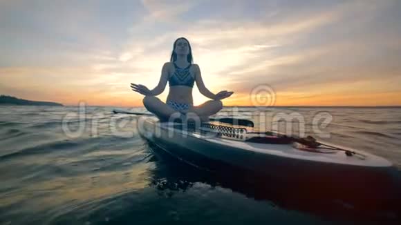 一个女人在水上练习瑜伽冥想4K视频的预览图