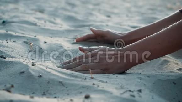 慢动作特写沙子穿过年轻女子的手指沙子穿过了一个视频的预览图