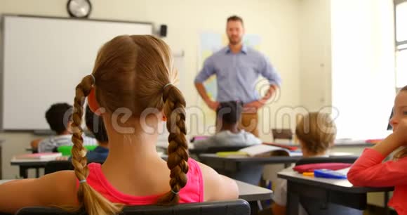 多民族学龄儿童在学校4k教室里坐在课桌前举手视频的预览图